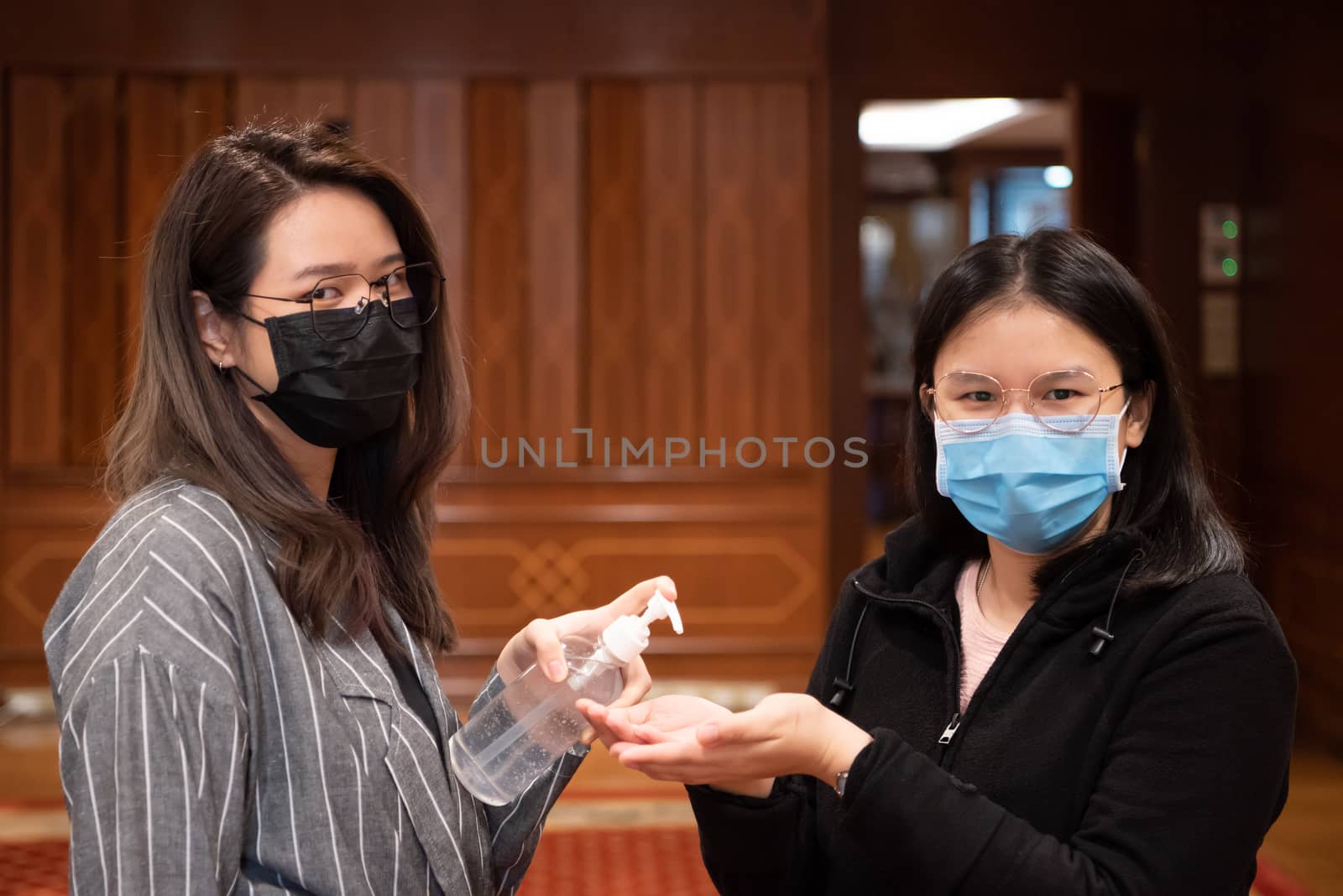 Asian women wearing mask and alcohol antibacterial hand gel respiratory protection mask against epidemic flu covid19 or corona virus with fear emotion in concept illness, outbreak, healthcare in life