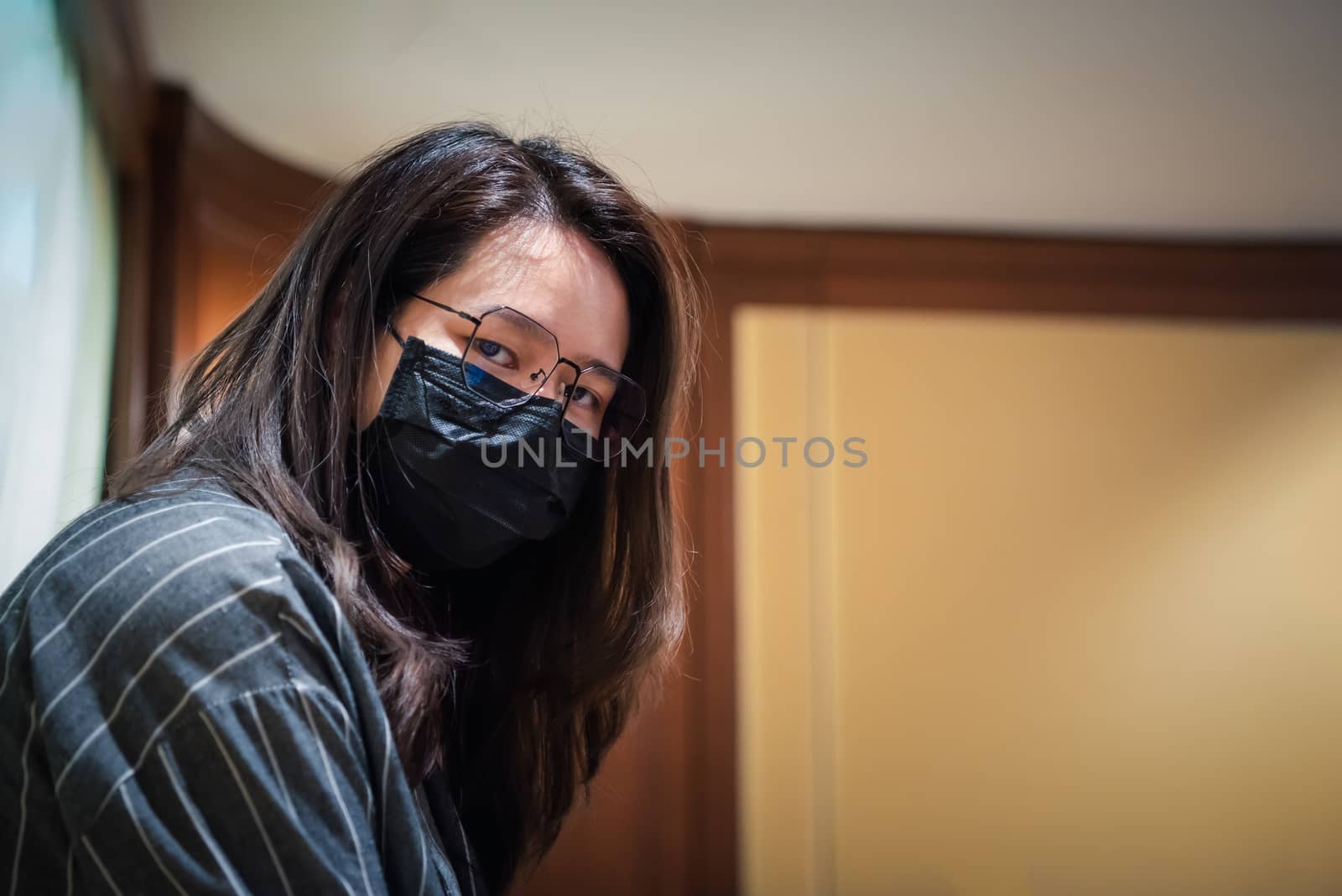 Asian pretty woman wearing mask respiratory protection mask against epidemic flu covid19 or corona virus from wuhan in office with fear emotion in concept illness, outbreak, healthcare in life