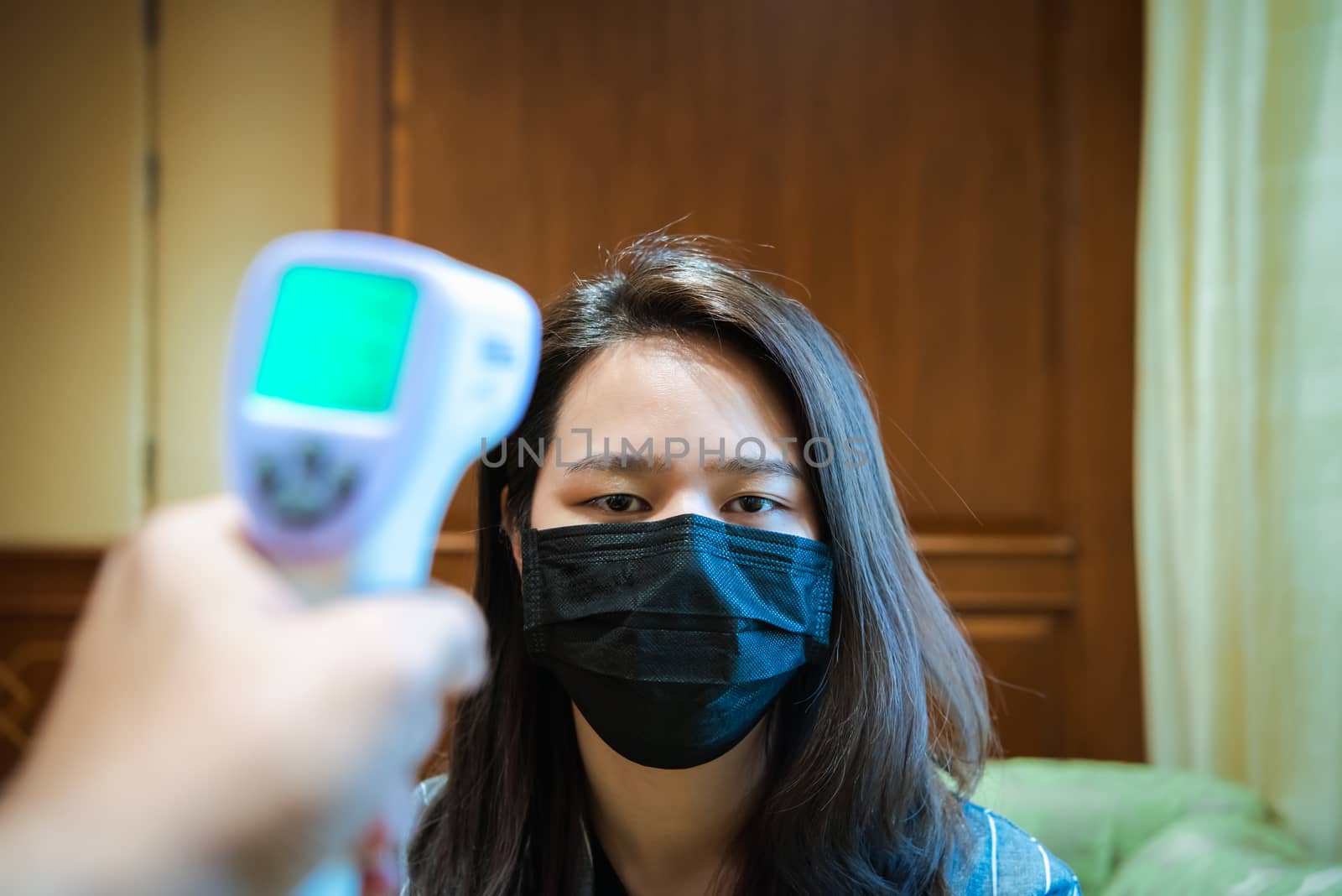 Woman wearing mask protection flu with thermoscan by PongMoji