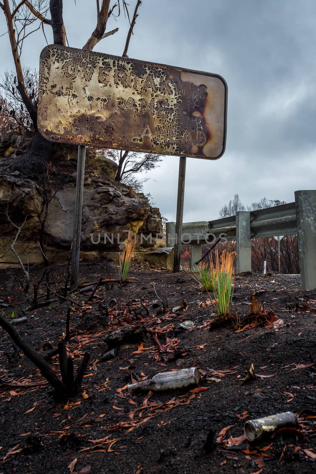 Burnt road sign, rubbish and landscape after bush fires in Blue Mountains, Australia. 