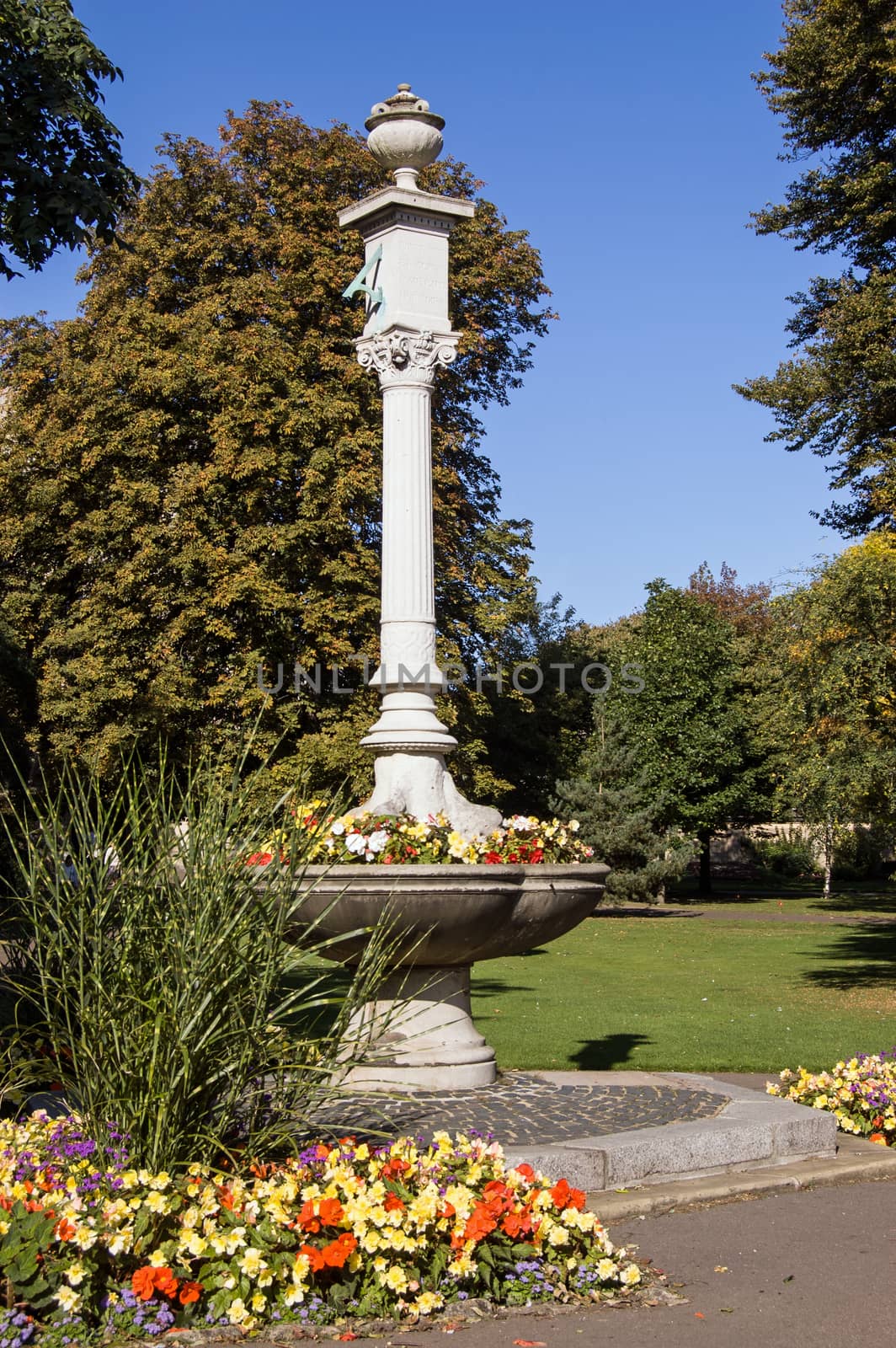 Victorian fountain, now used as a planter, in Abbey Gardens, Bury St Edmunds. The carved pillar with sundial was a gift from the Marquis of Bristol, unveiled in 1871.