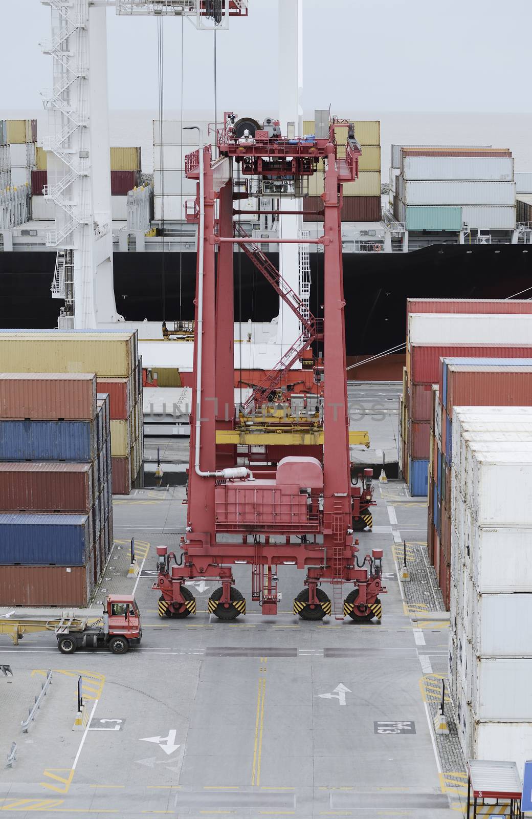 Cargo Containers Truck And A Crane In Storage Area Of Freight Port Terminal