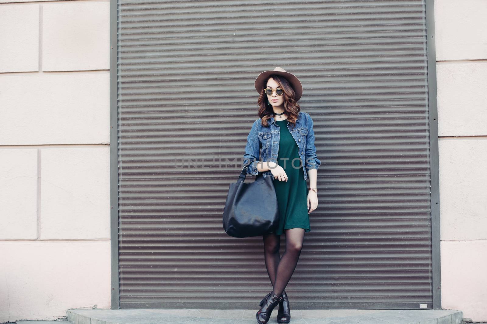 Stylish brunette in sunglasses and hat posing at street. by StudioLucky