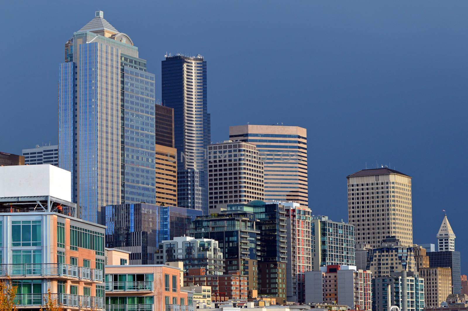 The sun peeks through a break in the clouds and lights the Seattle skyline