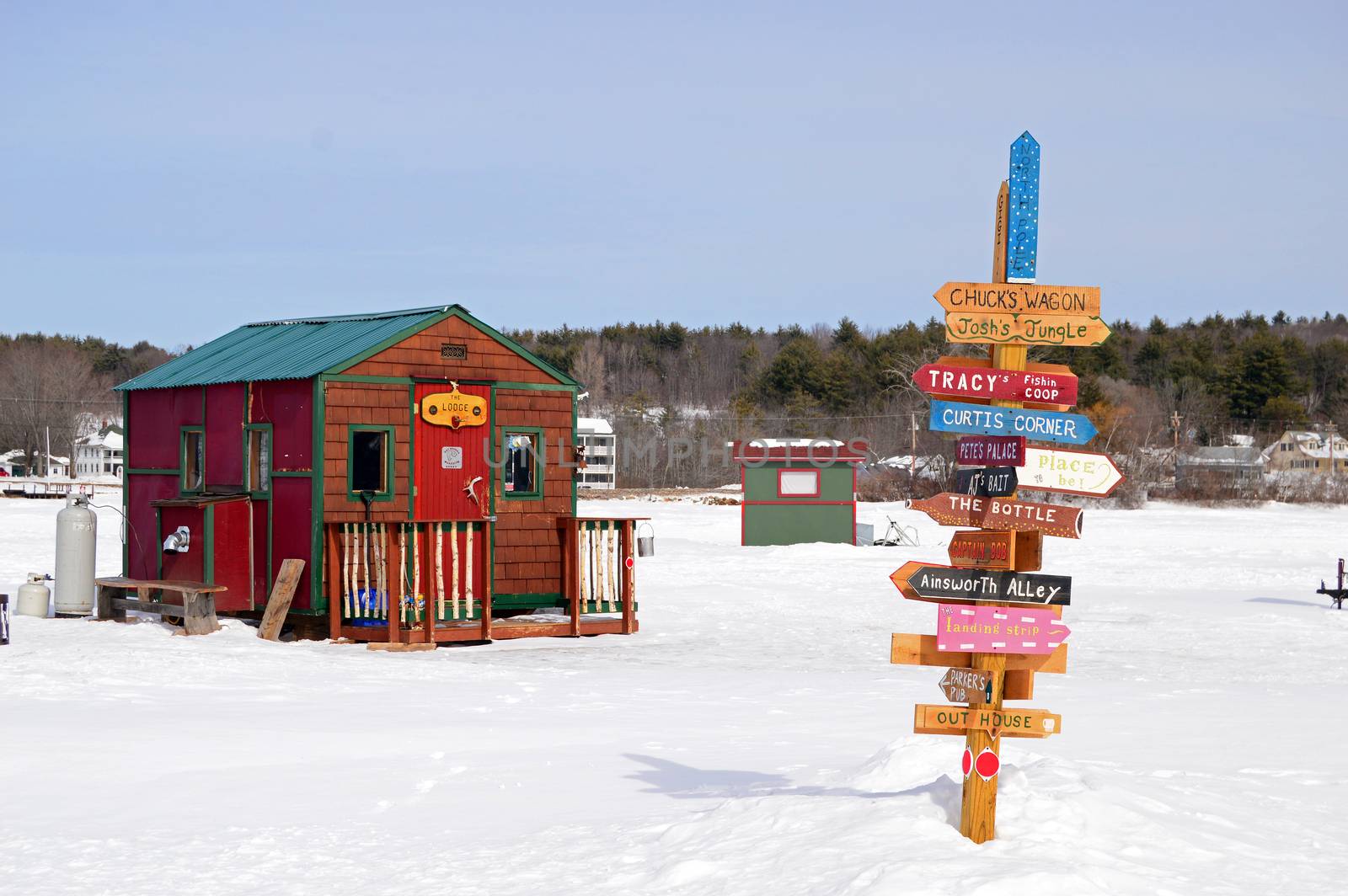 Ice fishing huts on a frozen lake by Kirkikis