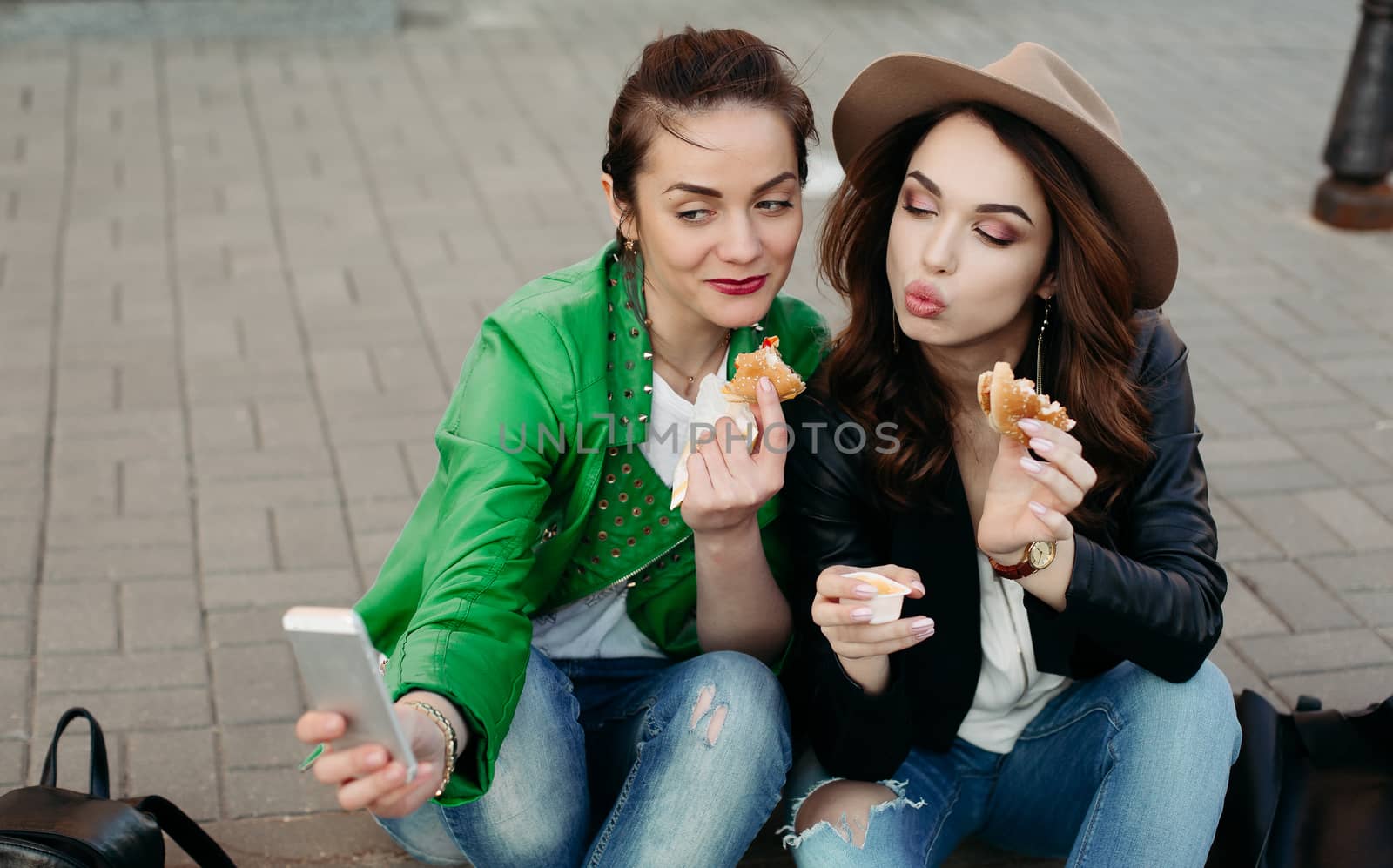 Positive girls eating hamburgers and taking self portrait. by StudioLucky