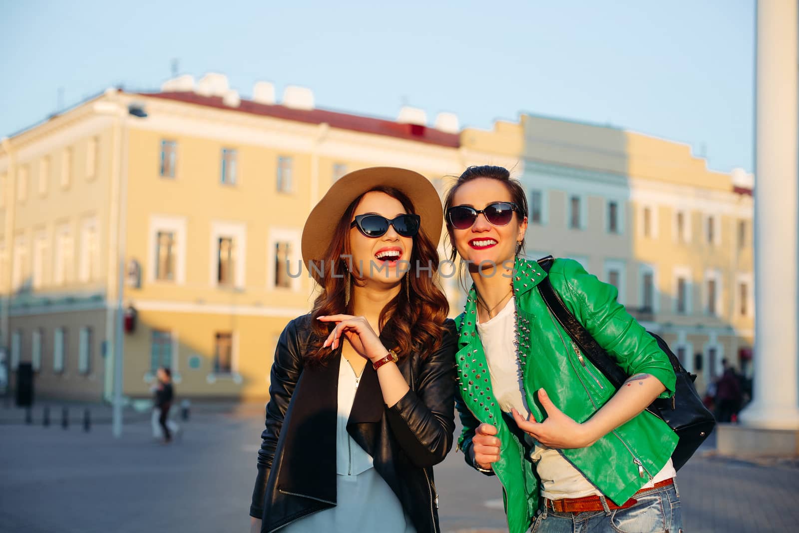 Shocked girls walking at street and pointing by finger away. by StudioLucky