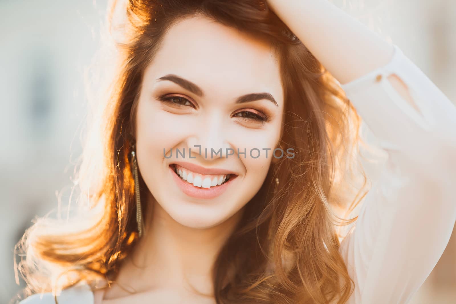 Beautiful positivity brunette woman in hat, white blouse, jeans walking at sunset in city, after shopping and beauty salon. Smiling fashionable girl stylish wearing posing at camera. Hipster look.