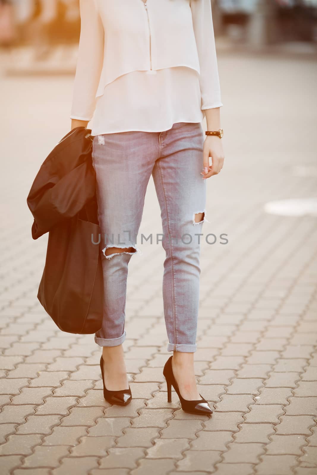 Brunette woman in hat walking at sunset after shopping. by StudioLucky