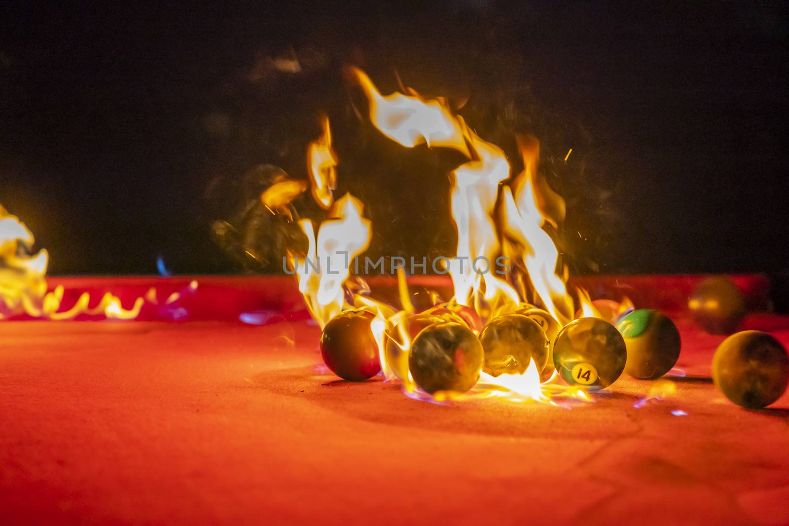 Billiard balls are photographed on fire while sitting outdoors in an open environment