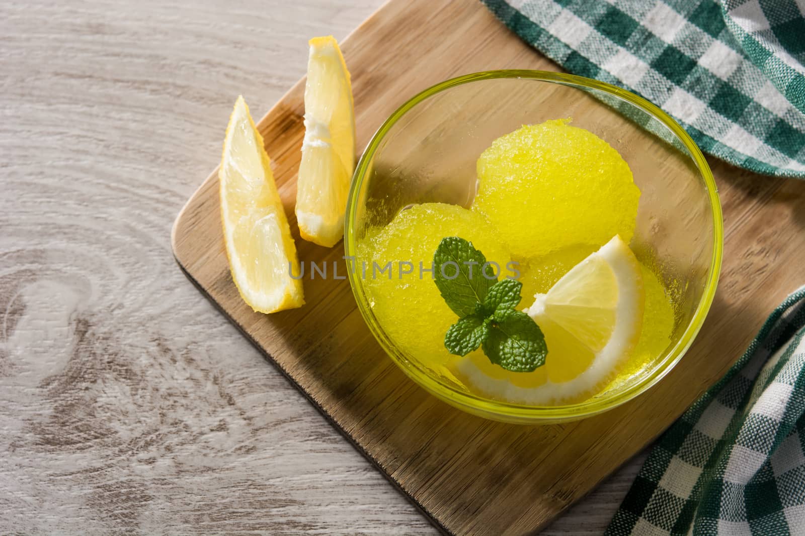 Lemon sorbet in glasses on white wooden background