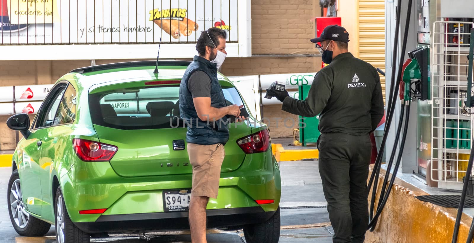 La Mexicana, Santa Fe, Mexico City: June 9, 2020. Gas station employee charging a user for a credit card. mouth covers