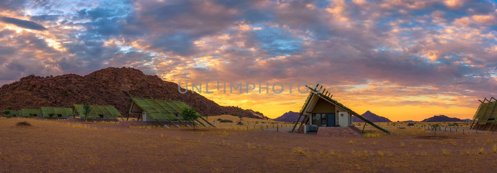 Sunrise above small chalets of a desert lodge near the Namib-Naukluft National Park close to Sossusvlei in Namibia.