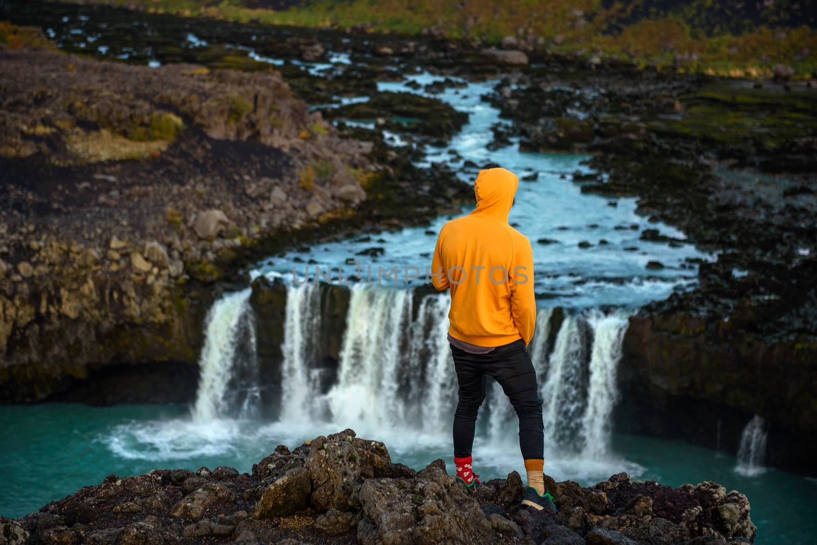 Hiker standing at the edge of the Thjofafoss waterfall in Iceland by nickfox