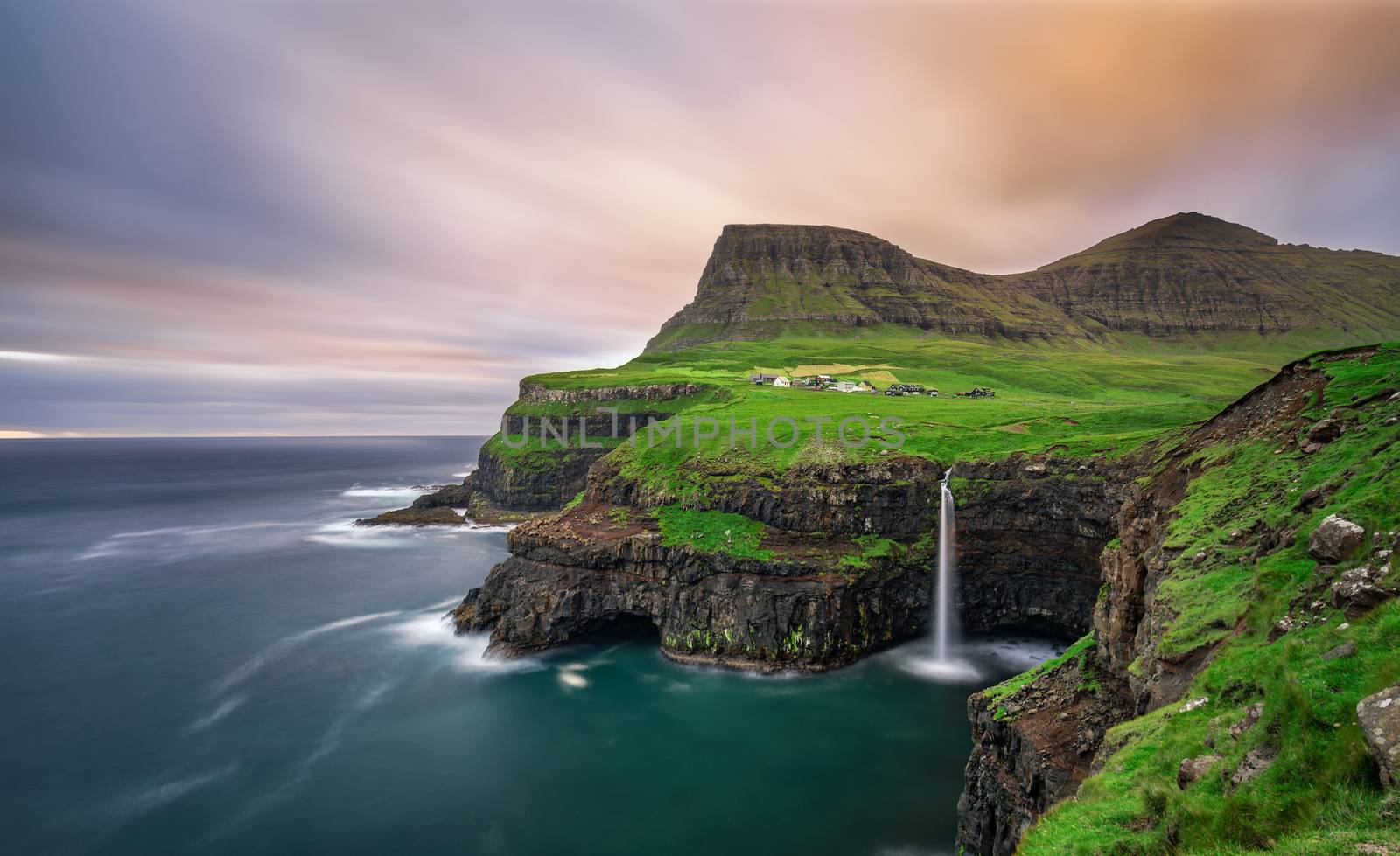 Gasadalur village and its iconic waterfall, Vagar, Faroe Islands, Denmark. Long exposure.