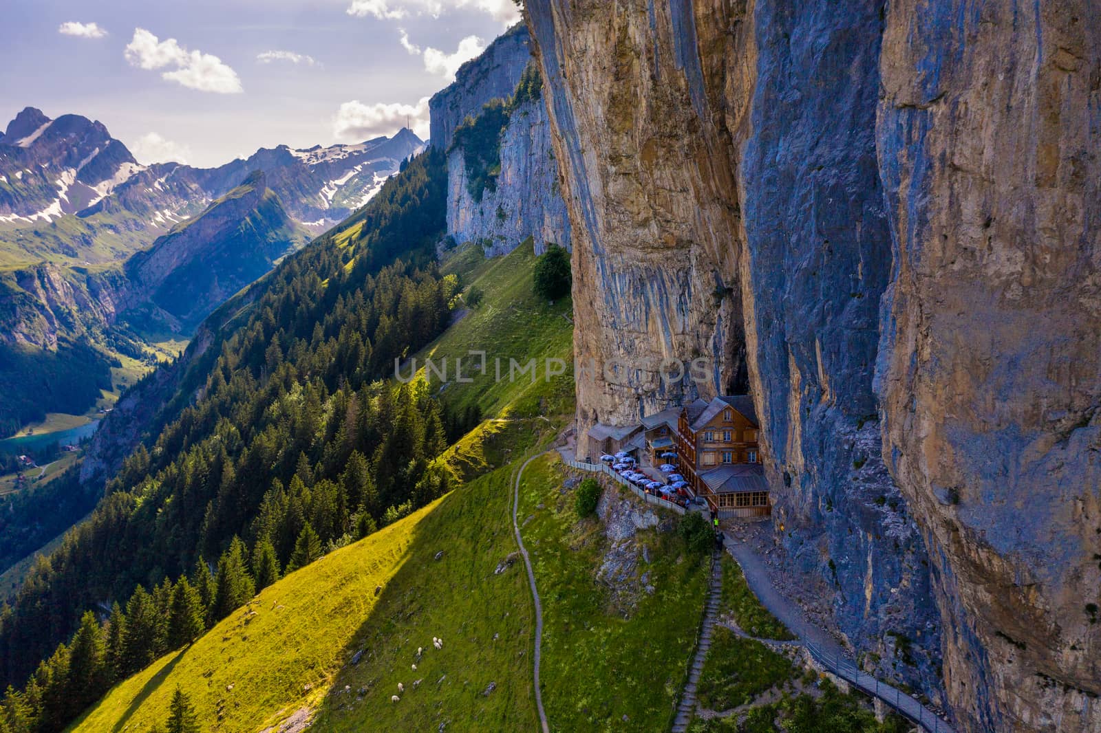 Swiss Alps and a restaurant under a cliff on mountain Ebenalp in Switzerland by nickfox