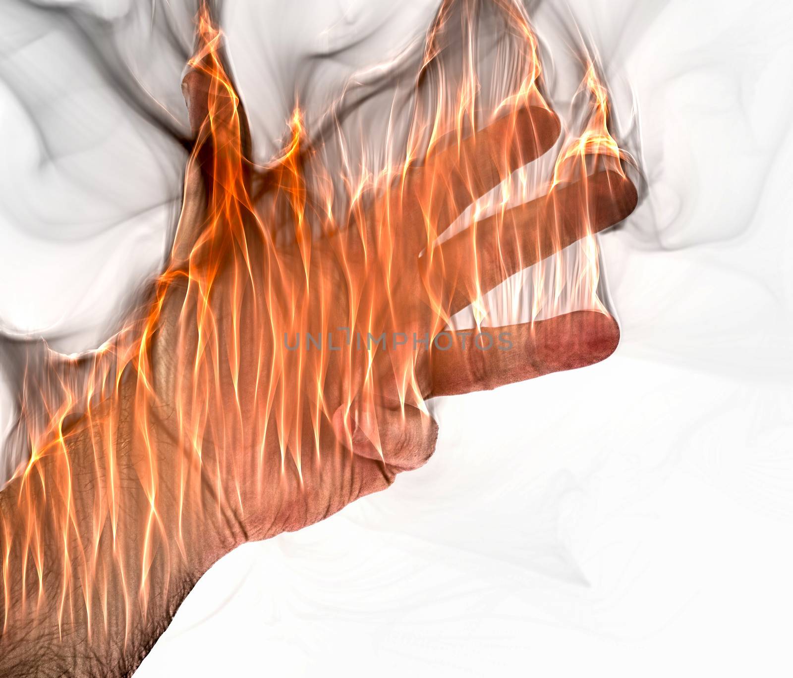 A human hand on fire burning with orange flames and some smoke in front of a white background