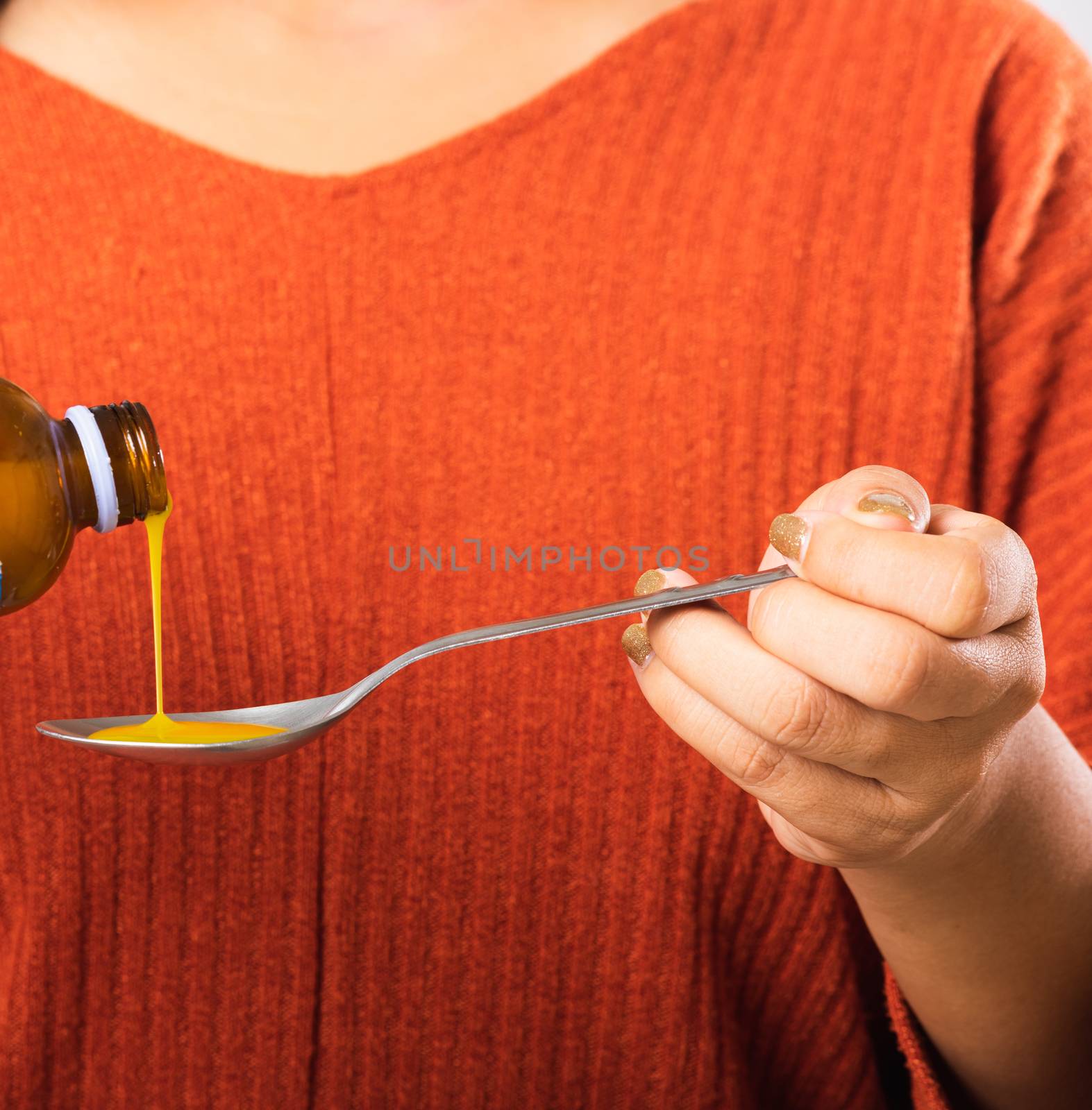 Close up hand of Asian mother woman pouring liquid medication or antipyretic syrup cough from bottle to spoon for baby or child, studio shit isolated on white background, Healthcare medicine concept