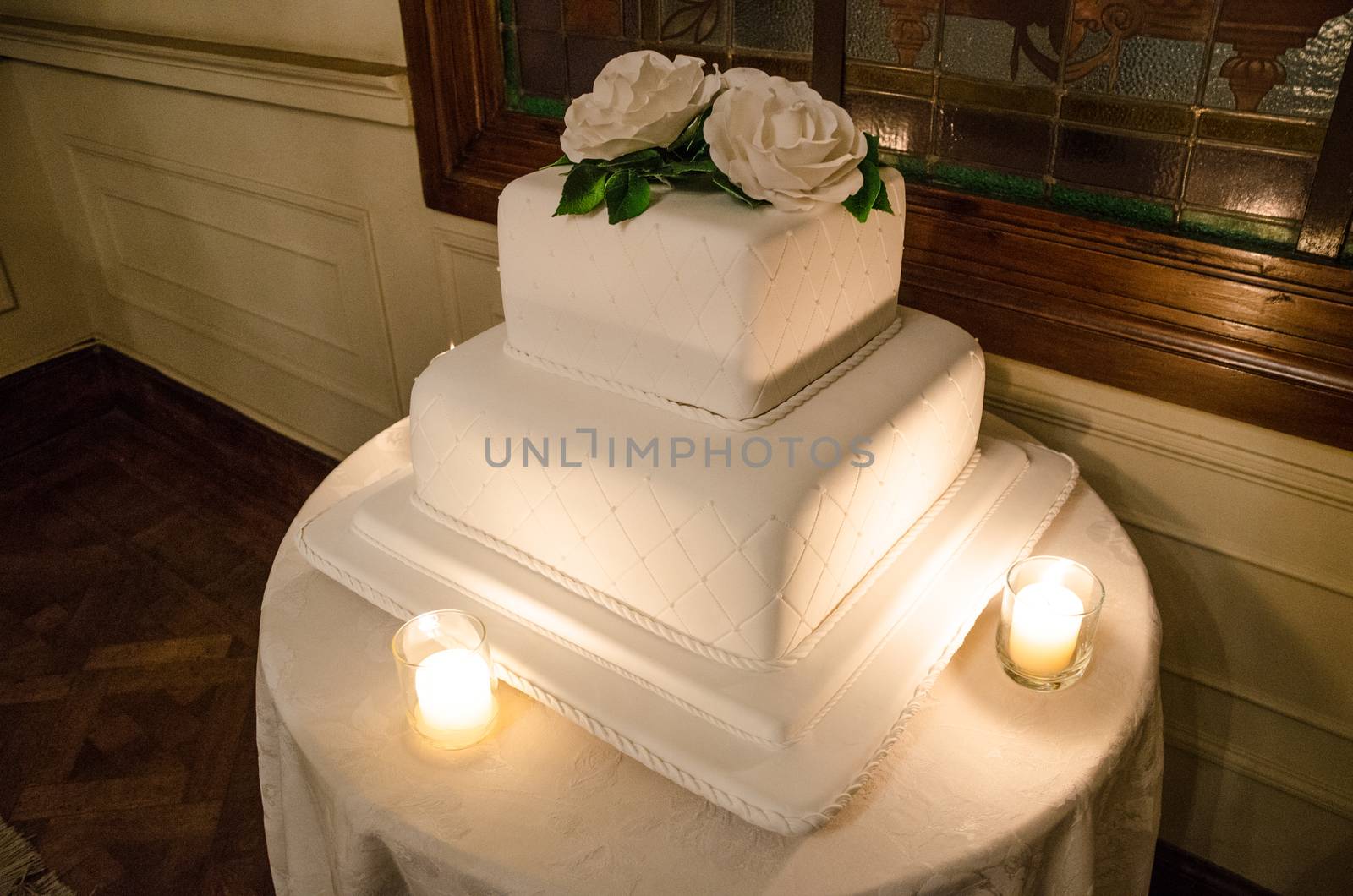 A white wedding cake with candles