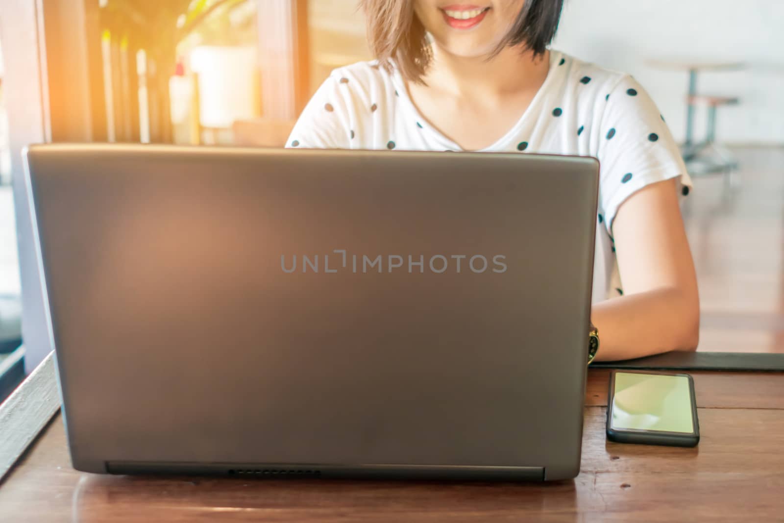 Happy woman smile while using laptop to work study on work desk with clean nature background background. Business, financial, trade stock maket and social network concept.