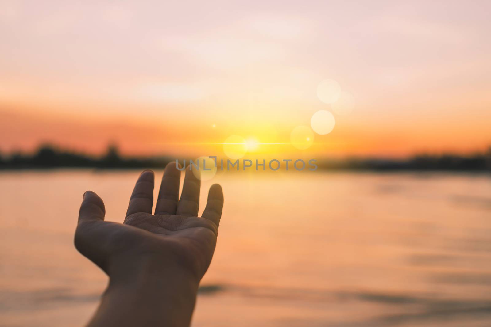 Woman hands reach out to the sky like praying in front of sky background.