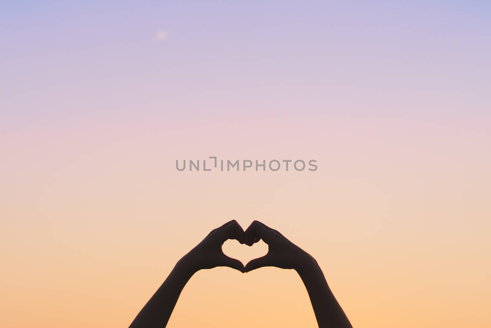 Woman hand do heart shape on blue sky  and bokeh background. by Suwant