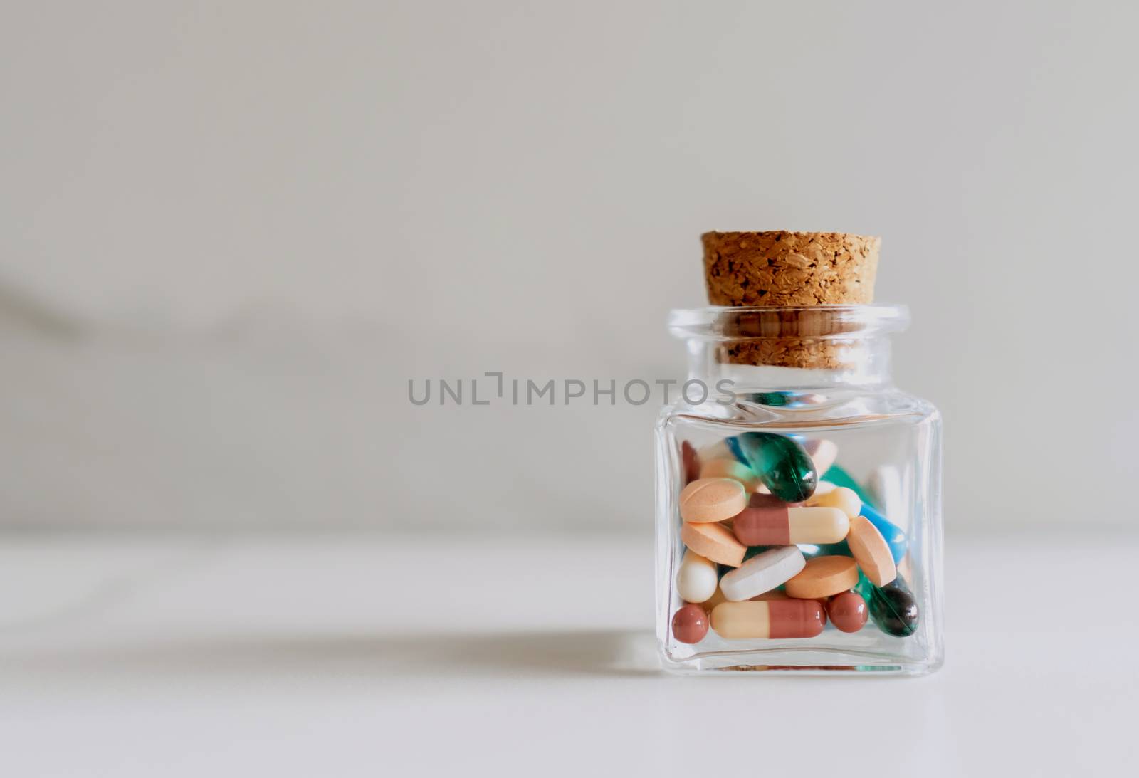 Top view of medicine tablets pour from pills bottle of marble texture white background. Health care medical lifestyle. by Suwant