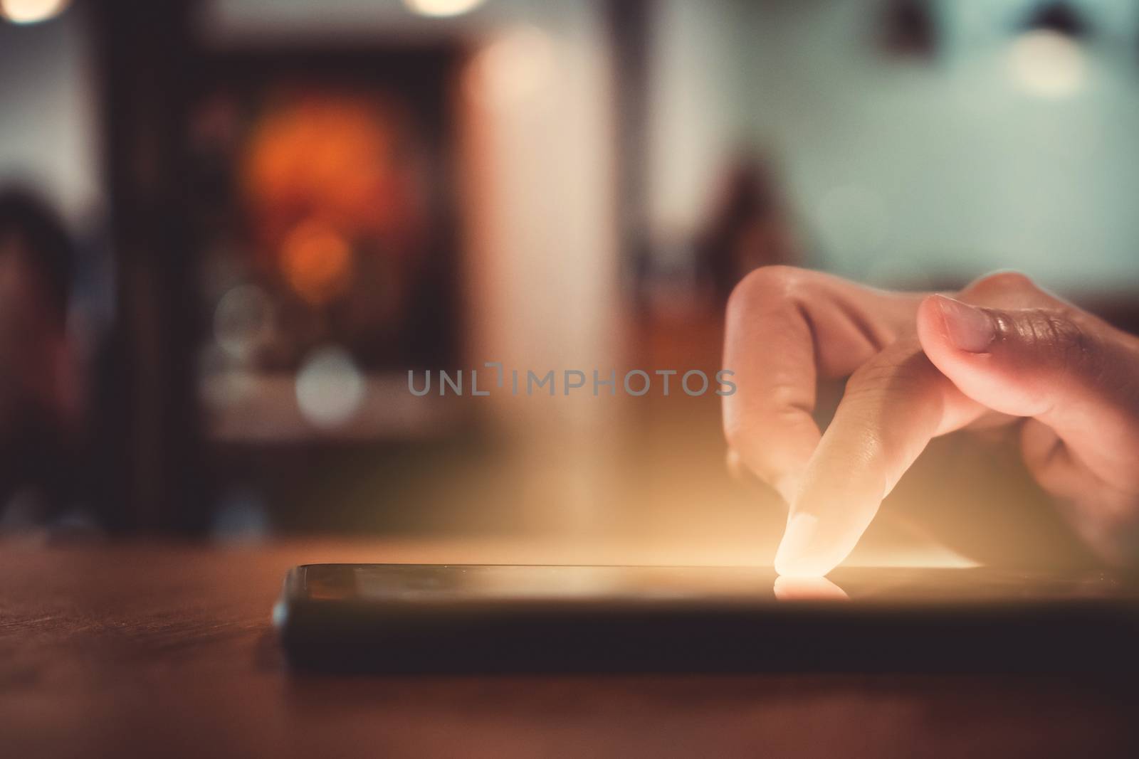 Woman hand use smartphone to do work business, social network, communication in public cafe work space area.