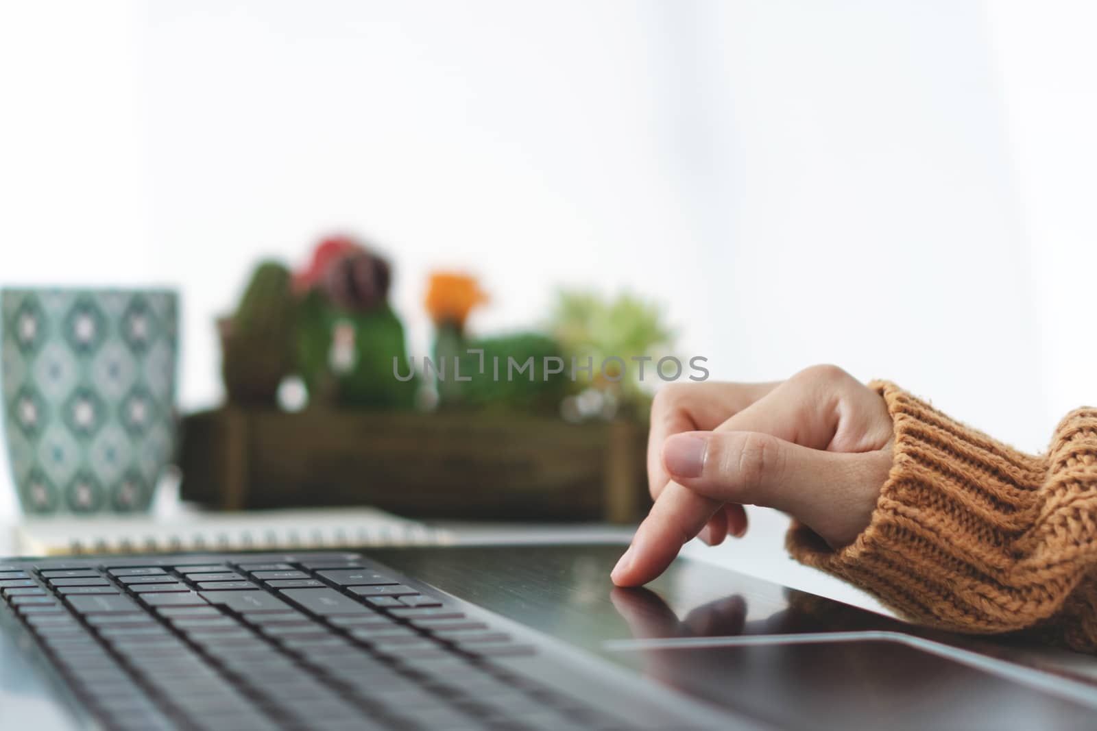 Woman hand using laptop or smartphone to work study on work desk with clean nature background background. Business, financial, trade stock maket and social network concept.