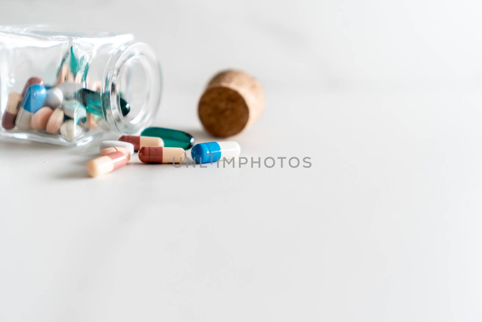 Top view of medicine tablets pour from pills bottle of marble texture white background. Health care medical lifestyle. by Suwant