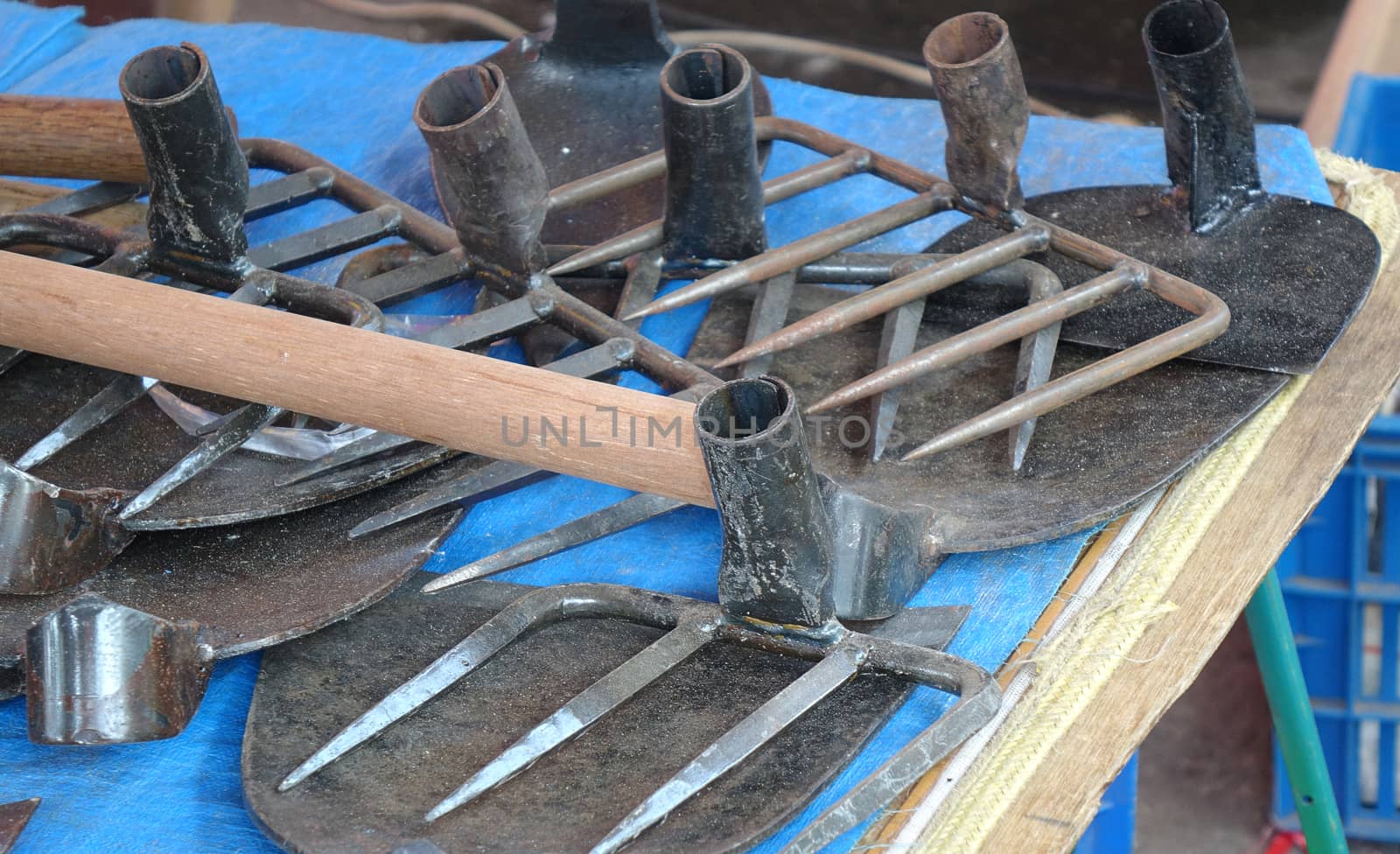 A street vendor sells handcrafted agricultural and gardening tools