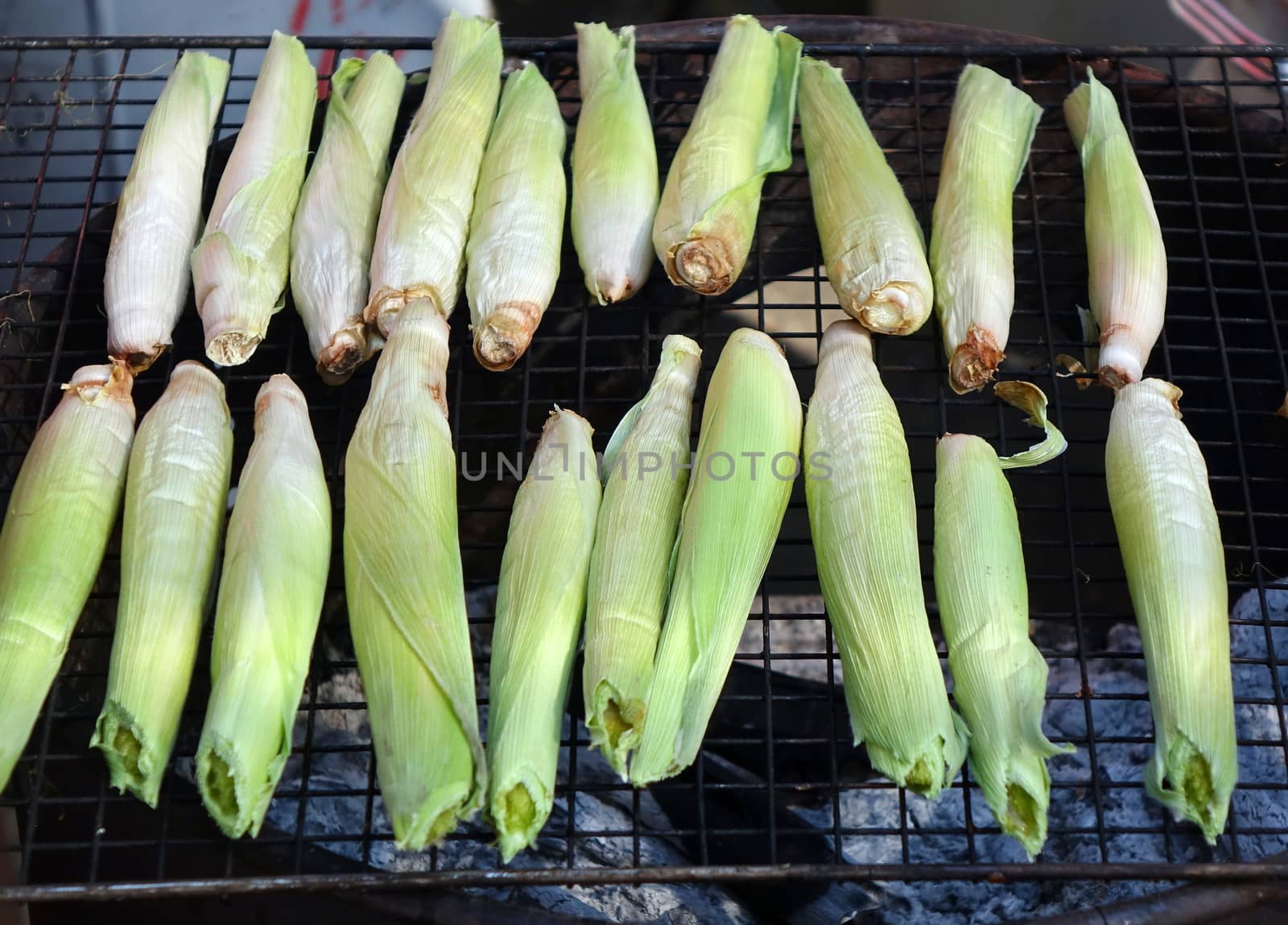 Baby corns are cooked on a charcoal grill