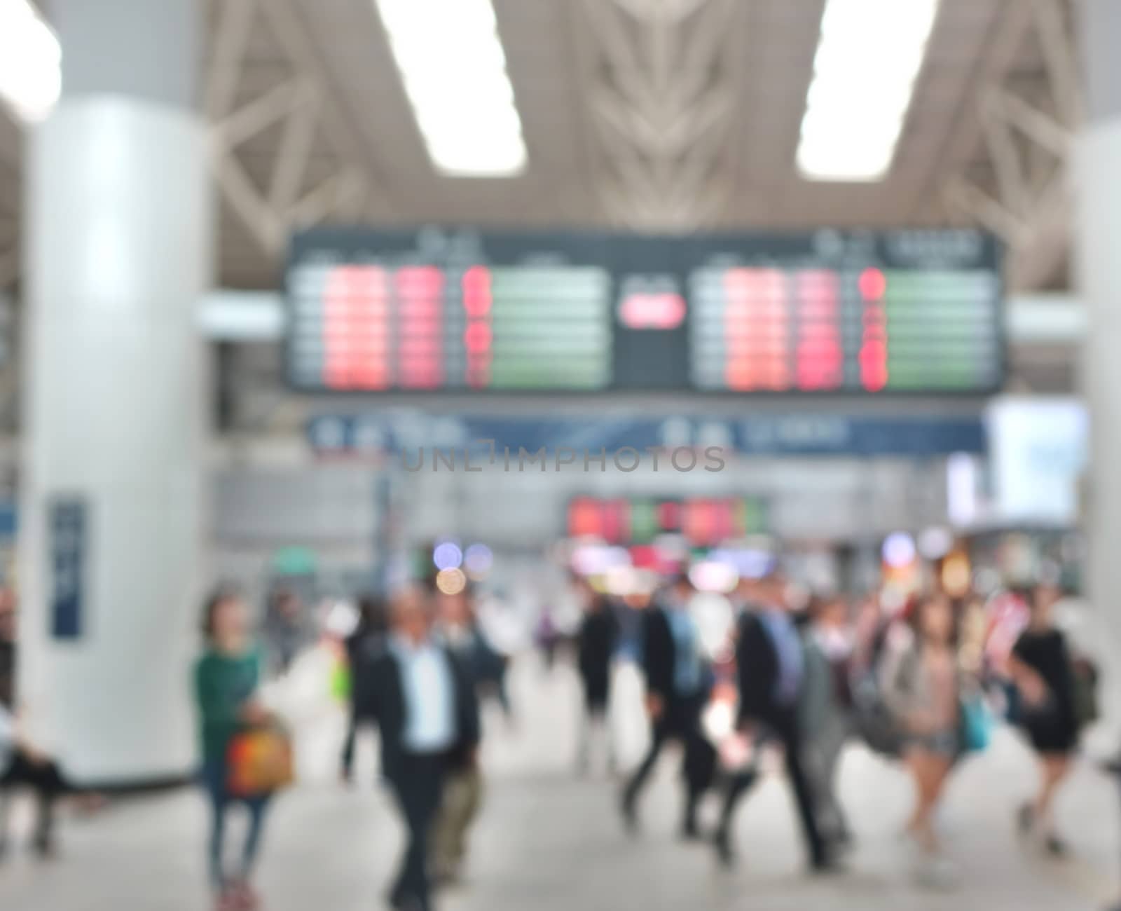A blurred background of a busy transportation terminal such as a bus or train station
