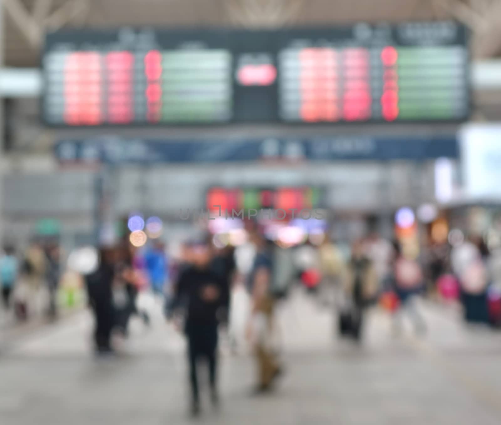 A blurred background of a busy transportation terminal such as a bus or train station