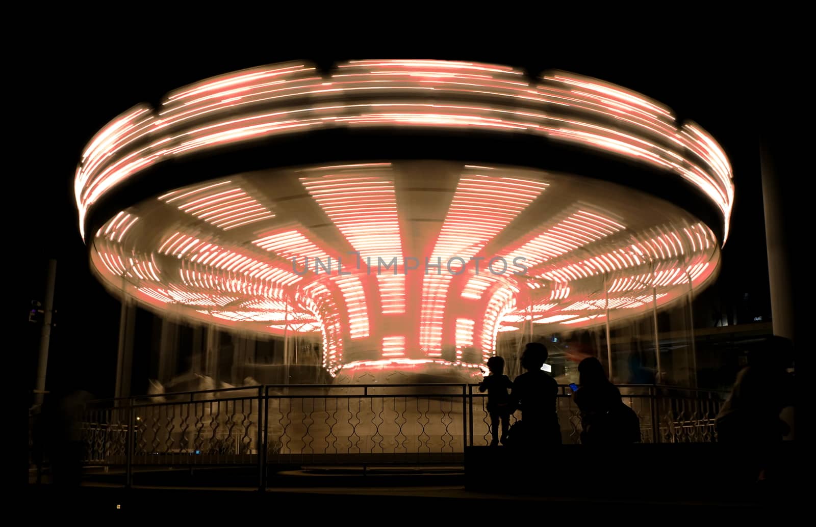 Image of a carousel in long time exposure creating rotating motion effect
