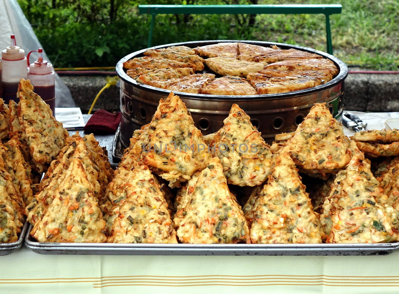 A street vendor sells fried pancakes with vegetables