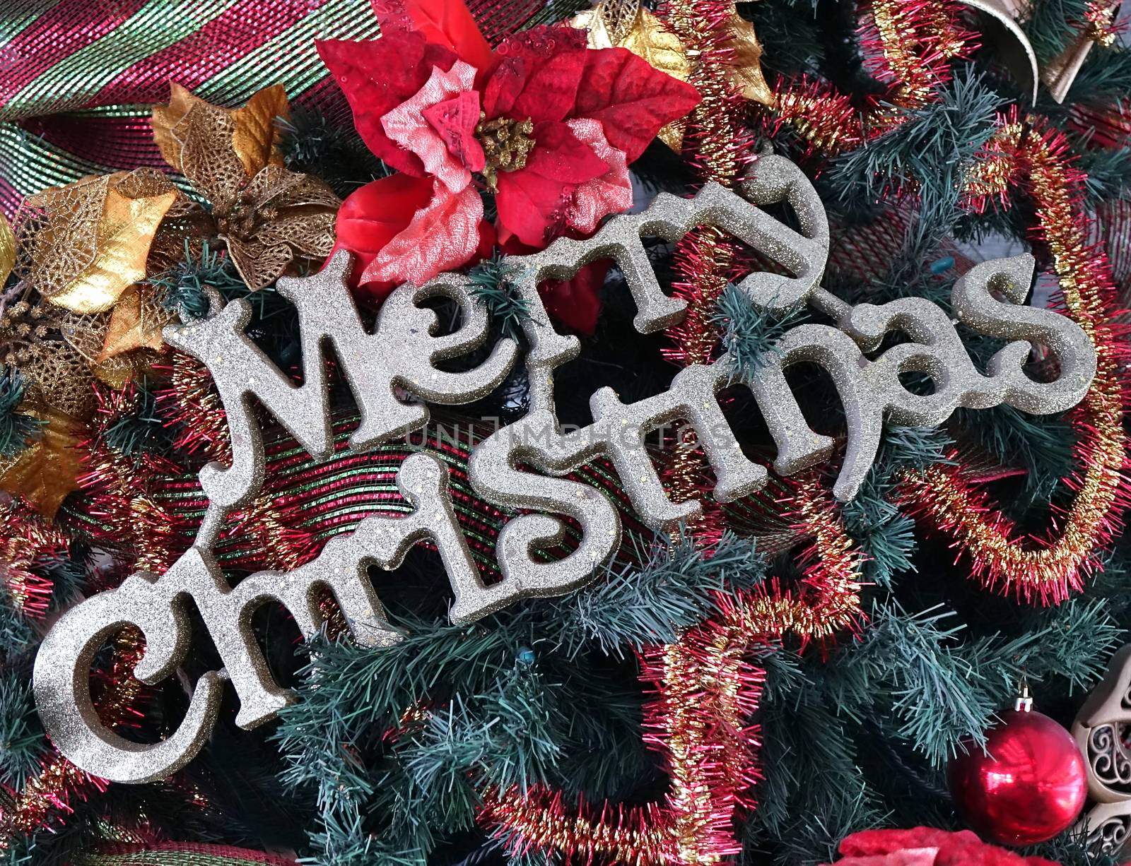 Christmas tree detail with Merry Christmas letters and colorful decorations
