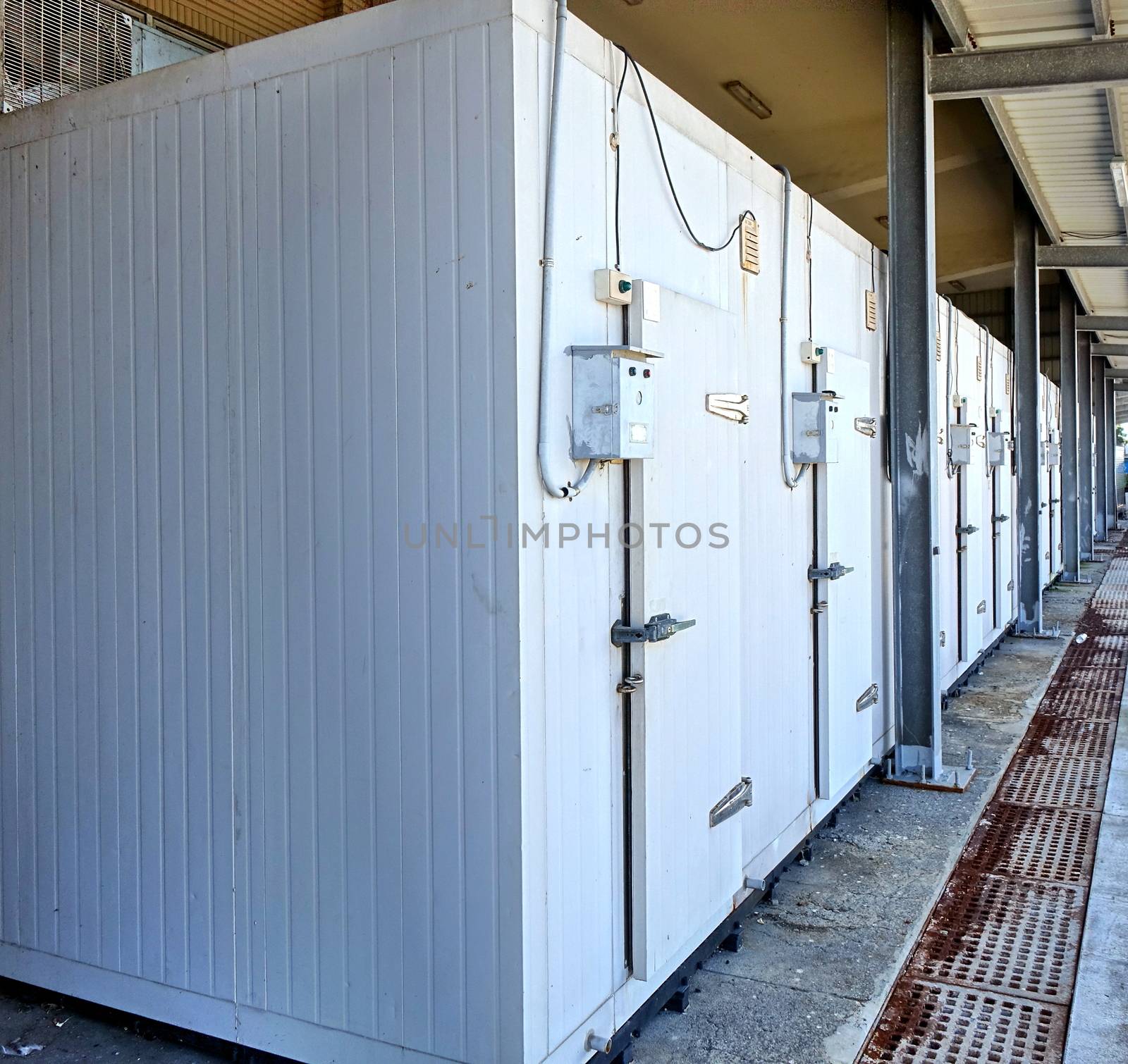 A row of walk-in refrigerators and freezer at a commercial cold storage facility