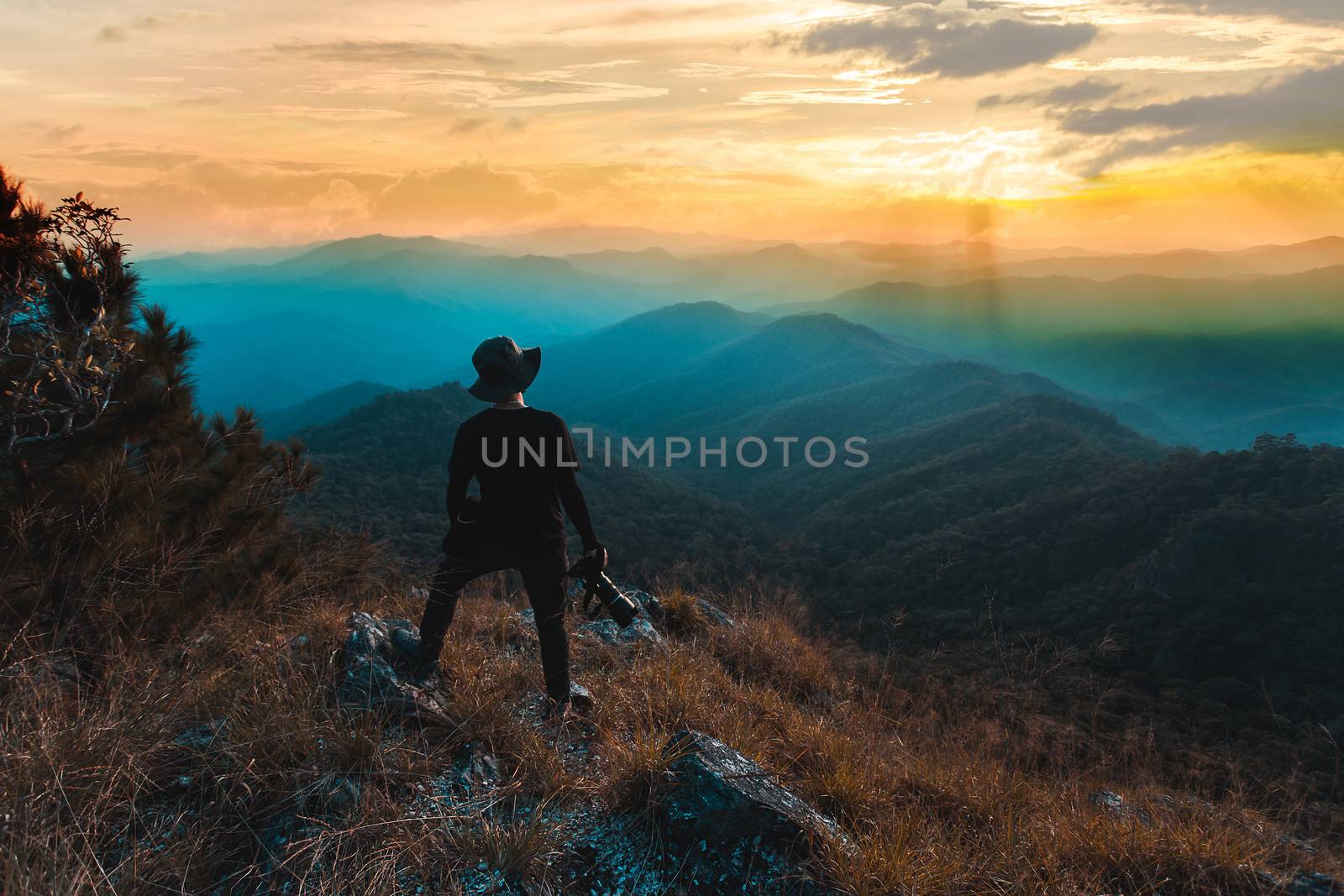 Silhouette of man hold up hands on the peak of mountain,success concept