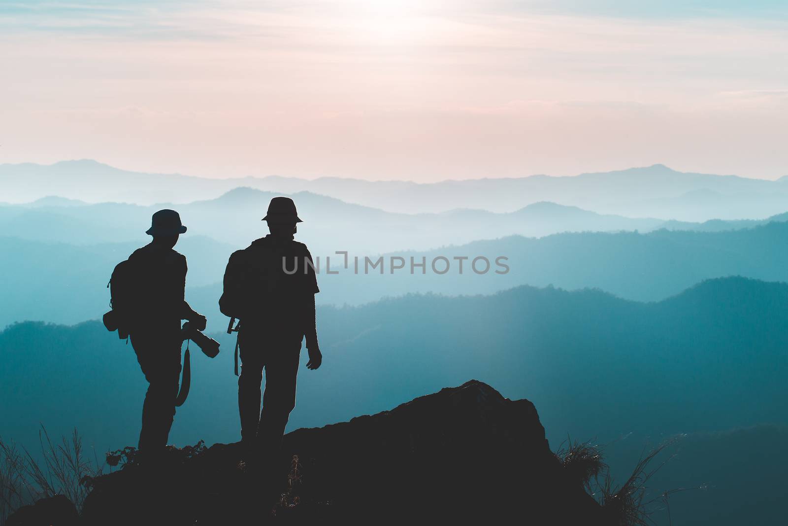 Silhouette of man hold up hands on the peak of mountain,success  by freedomnaruk