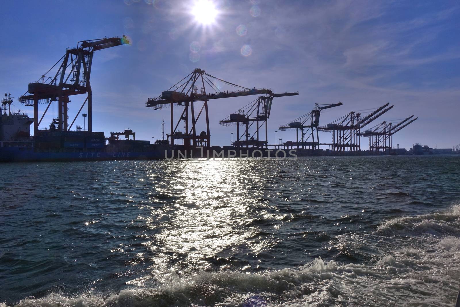 A row of loading cranes for containers are seen in port
