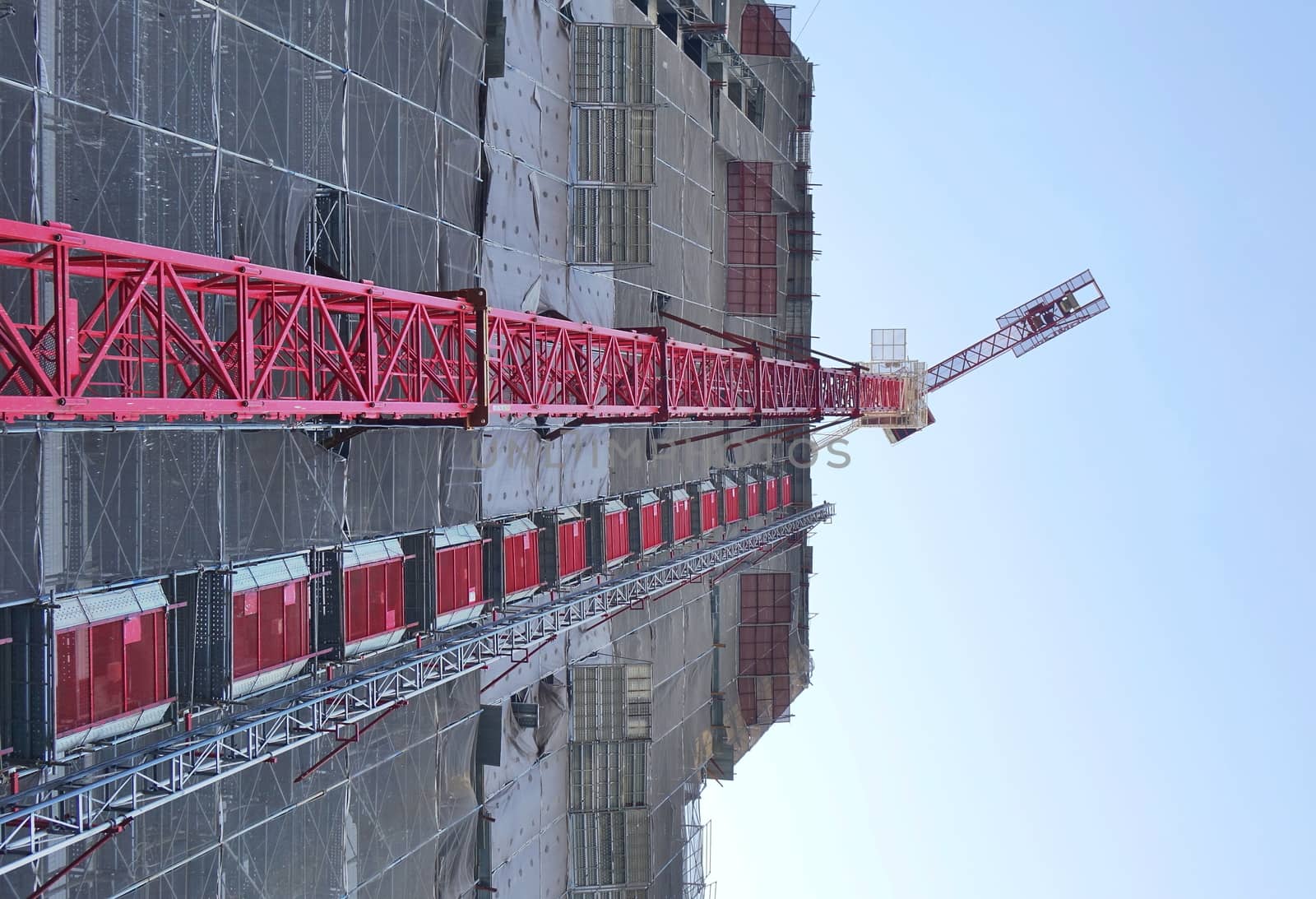 Large scale construction site with crane seen in perspective
