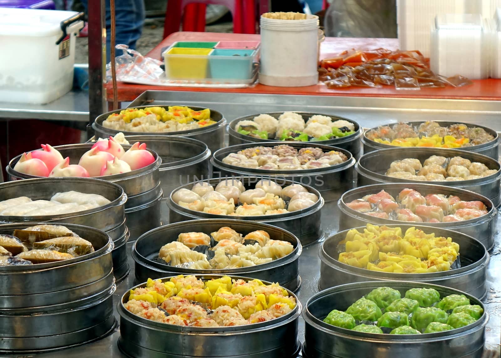 An outdoor vendor sells Cantonese Dim Sum dishes cooked in metal steamers