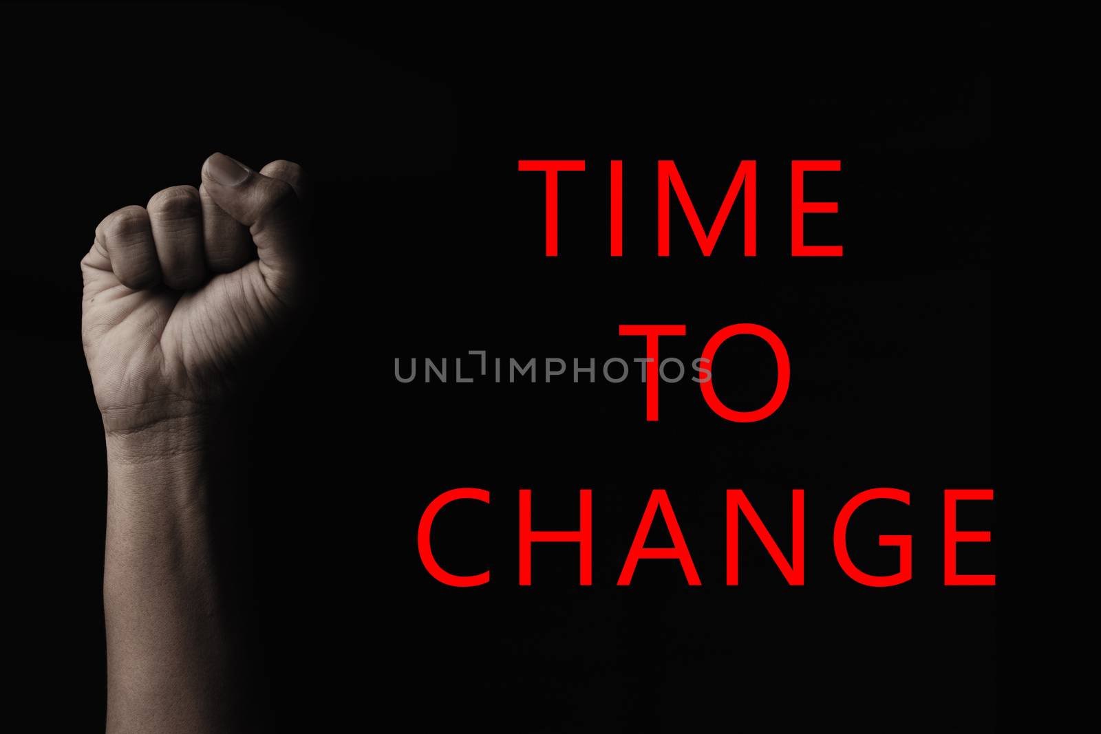 Concept against racism or racial discrimination by showing with hand gestures fist with Time to change typography.