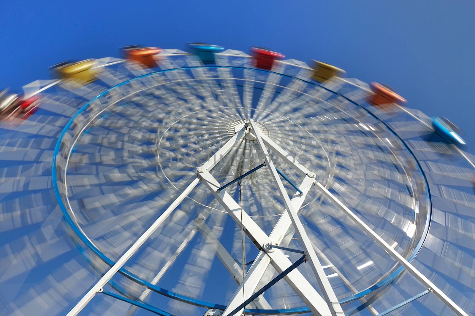 A ferris wheel with colorful cabins at a local fun fair
