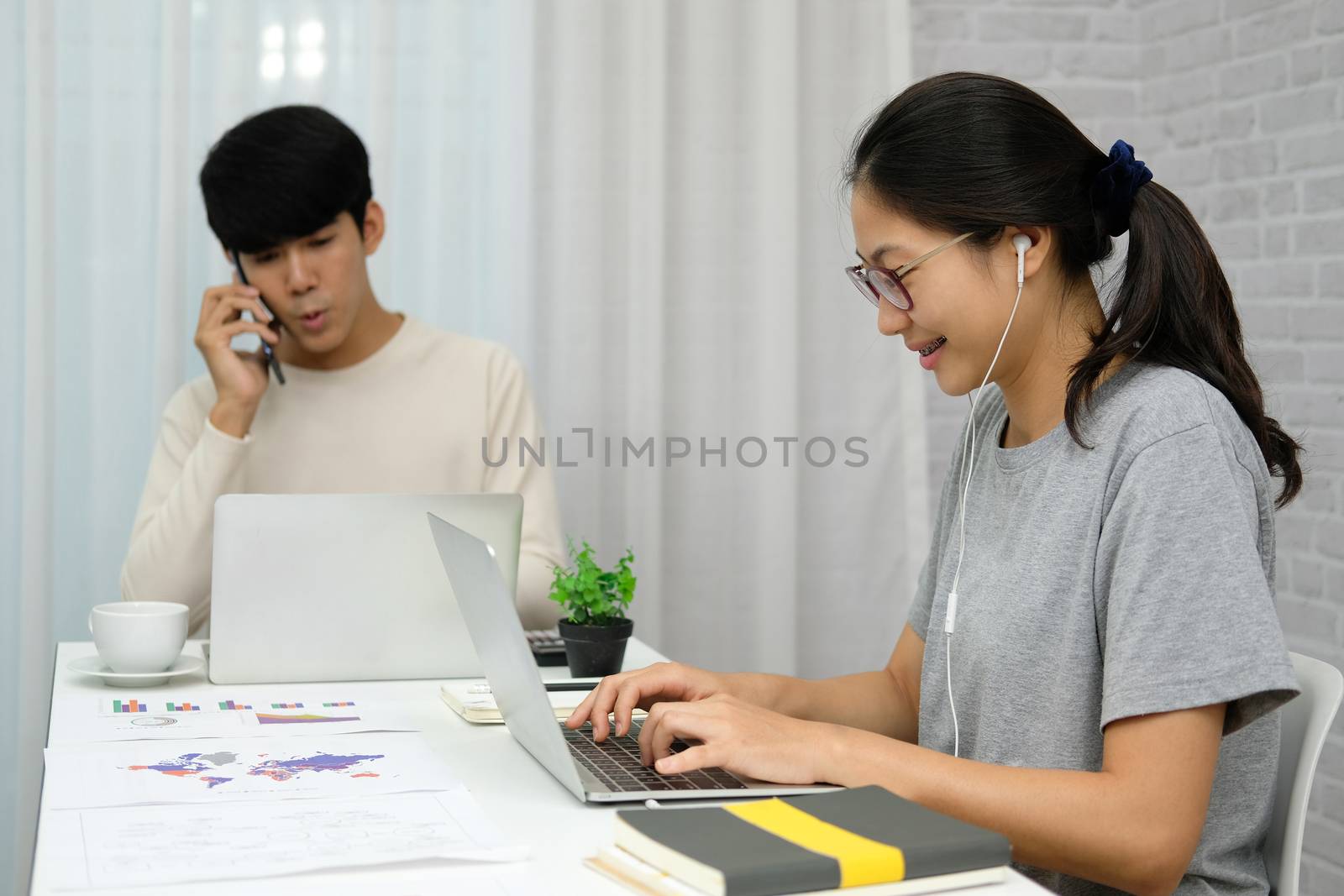 man talking on phone. woman using computer for online video conference meeting. tartup teamwork team working together at home