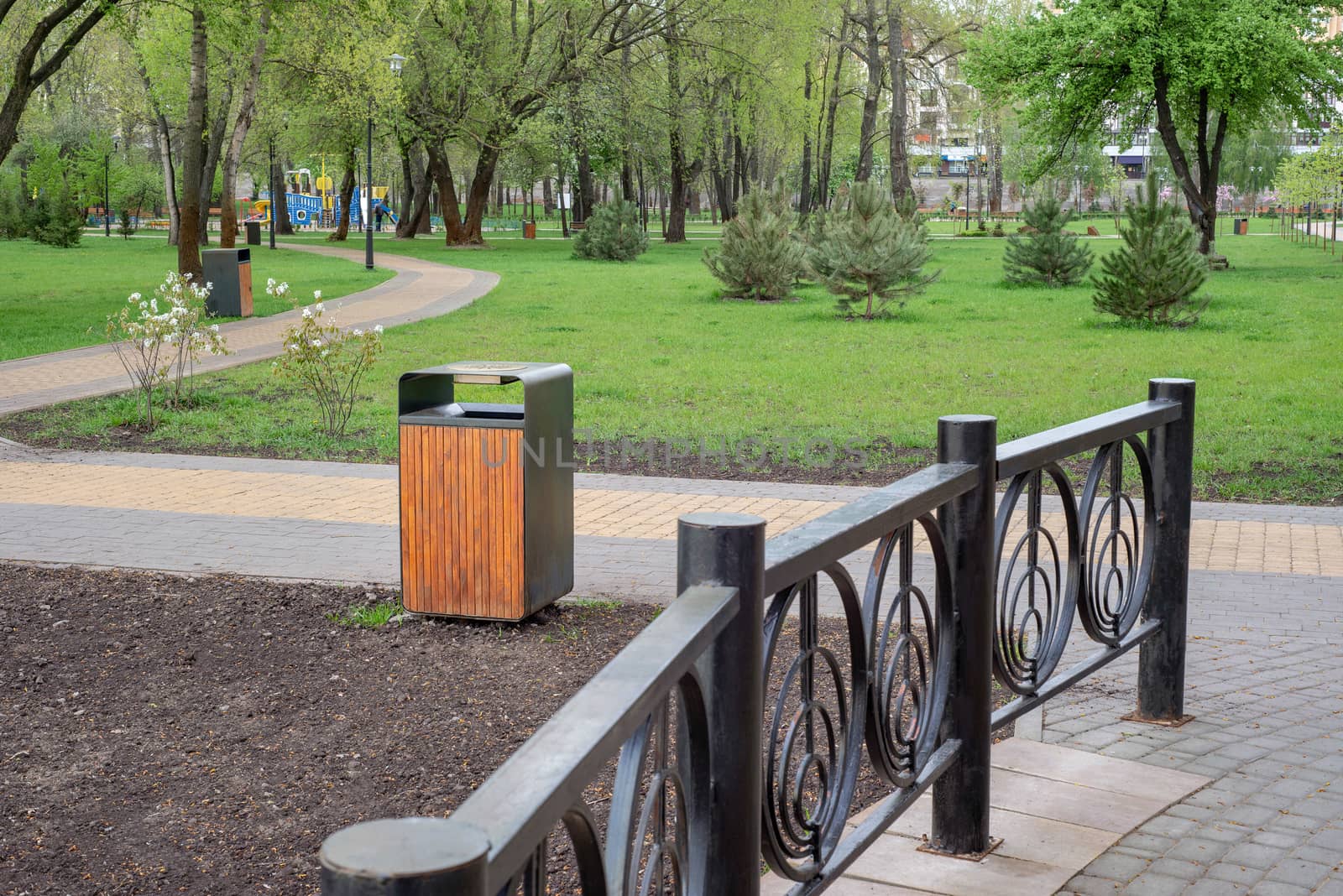 A wooden and metallic trash bin in the Natalka park of Kiev, Ukraine, close to the Dnieper river in spring