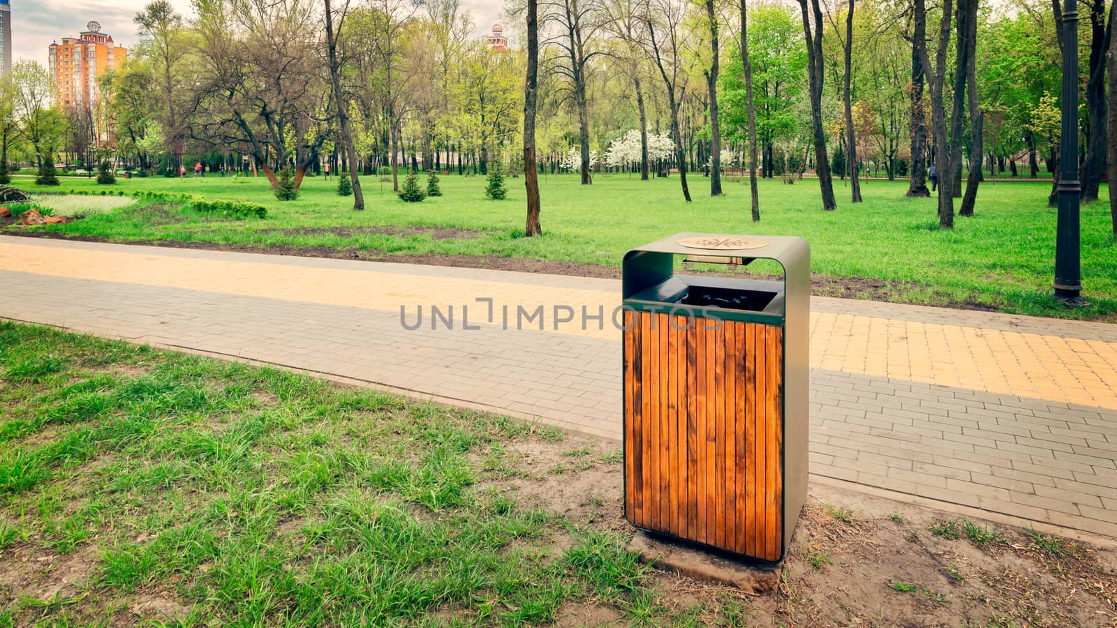 A wooden and metallic trash bin in the Natalka park of Kiev, Ukraine, close to the Dnieper river in spring