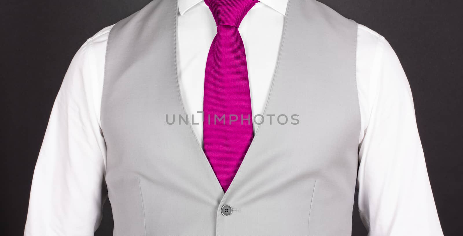 Man in a grey suit with pink tie, close-up