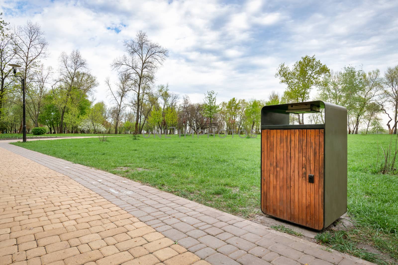 A wooden and metallic trash bin in the Natalka park of Kiev, Ukraine, close to the Dnieper river in spring